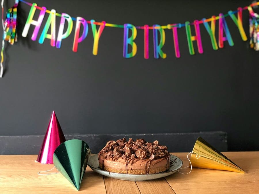 Chocolate birthday cake with party hats and a banner