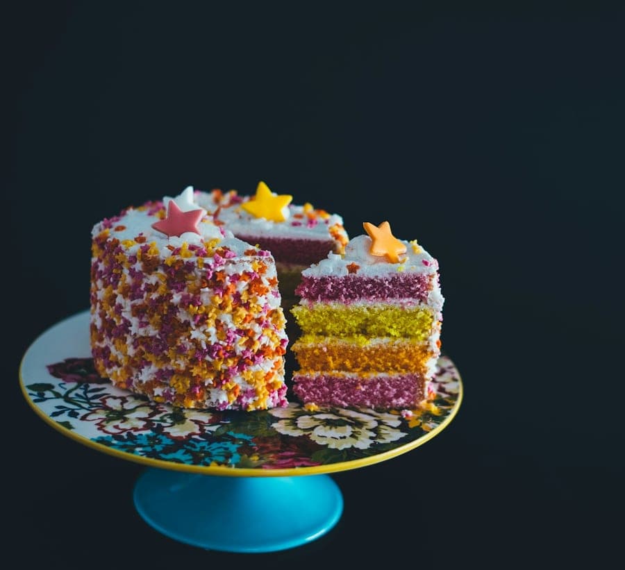 Rainbow layer cake with sprinkles, cut to show the layers