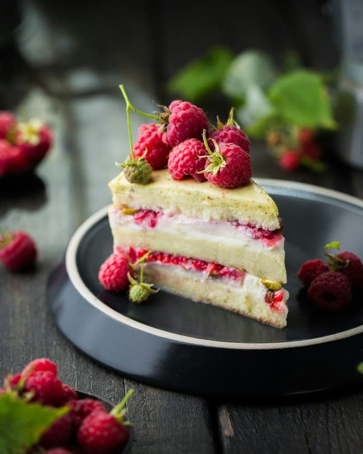 Slice of raspberry and pistachio layer cake